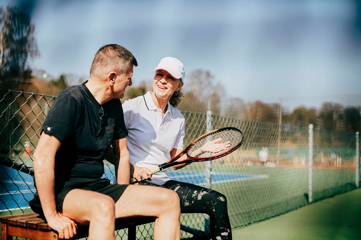 Två personer spelar tennis utomhus